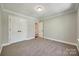 Bedroom with neutral carpet and paint, white trim, and ensuite bathroom entrance at 7435 Hammond Dr, Charlotte, NC 28215