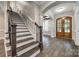 Elegant foyer featuring hardwood floors, a staircase, and a striking wood-framed doorway at 7435 Hammond Dr, Charlotte, NC 28215
