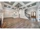 Open-concept living room featuring hardwood floors, a coffered ceiling, and an elegant staircase at 7435 Hammond Dr, Charlotte, NC 28215