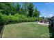 Well-maintained backyard with lush lawn, trees, and a cozy patio area at 7530 Porrera St, Charlotte, NC 28214