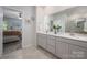 Bright en-suite bathroom featuring dual sinks, quartz counters, tile flooring, and a walk-in shower at 7530 Porrera St, Charlotte, NC 28214