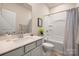 Bright bathroom featuring a tub with shower, gray vanity, and modern fixtures at 7530 Porrera St, Charlotte, NC 28214