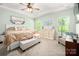 Airy main bedroom with tray ceiling, large windows, beige walls, decorative pillows and seating area at 7530 Porrera St, Charlotte, NC 28214