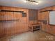 Basement featuring wood paneling, a workbench, and ample shelving at 7608 Surreywood Pl, Charlotte, NC 28270