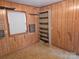 Basement featuring wood paneling and some shelving at 7608 Surreywood Pl, Charlotte, NC 28270