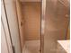 Bathroom showcasing a shower with glass doors and light brown tiled walls at 7608 Surreywood Pl, Charlotte, NC 28270