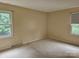 Bedroom with two windows offering natural light and tan walls at 7608 Surreywood Pl, Charlotte, NC 28270