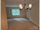 Traditional dining room features a chandelier and sunlit window creating a warm and inviting atmosphere at 7608 Surreywood Pl, Charlotte, NC 28270