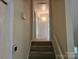 Hallway with carpeted staircase and neutral walls, leading to the upper level of the home at 7608 Surreywood Pl, Charlotte, NC 28270