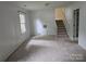 Light-filled living room with wood-paneled walls and a carpeted staircase, offering a warm atmosphere at 7608 Surreywood Pl, Charlotte, NC 28270