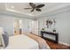 Stylish bedroom featuring a ceiling fan, tray ceiling, and console table with modern artwork at 8406 Flint Hill Dr, Charlotte, NC 28273