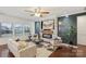 Cozy living room featuring a stone fireplace, modern decor, a ceiling fan, and large windows at 8406 Flint Hill Dr, Charlotte, NC 28273