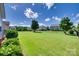 Well-maintained backyard featuring a large lawn, mature trees, and a black fence, perfect for outdoor activities at 8493 Twickenham Ter, Harrisburg, NC 28075