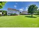 Spacious backyard with lush green grass, mature trees, and a black fence, providing privacy and beauty at 8493 Twickenham Ter, Harrisburg, NC 28075