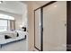 Modern bathroom with glass enclosed shower and a view into a bedroom with lots of natural light at 8493 Twickenham Ter, Harrisburg, NC 28075