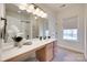Bright bathroom featuring a spacious vanity with white countertop, decorative accents, and tile flooring at 8493 Twickenham Ter, Harrisburg, NC 28075