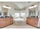 Luxurious bathroom with dual vanities, soaking tub, and abundant natural light at 8493 Twickenham Ter, Harrisburg, NC 28075