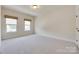 Spacious bedroom featuring two windows and neutral carpeting, creating a bright and airy atmosphere at 8493 Twickenham Ter, Harrisburg, NC 28075