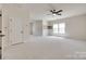 Large bonus room featuring neutral carpeting, a ceiling fan, and natural light, perfect for various activities at 8493 Twickenham Ter, Harrisburg, NC 28075