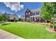 Beautiful two-story home featuring a lush green lawn and mature trees at 8493 Twickenham Ter, Harrisburg, NC 28075