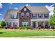 Charming two-story home with a combination of stone and siding and a well-manicured lawn at 8493 Twickenham Ter, Harrisburg, NC 28075