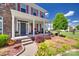 Inviting front porch with stone steps, decorative columns, and cozy seating at 8493 Twickenham Ter, Harrisburg, NC 28075
