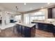 Bright kitchen with an island, granite countertops, stainless steel appliances and dark wood cabinets at 8493 Twickenham Ter, Harrisburg, NC 28075