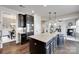 Open kitchen with a large island, granite countertops, stainless steel appliances and dark wood cabinets at 8493 Twickenham Ter, Harrisburg, NC 28075
