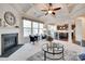 Cozy living room featuring fireplace, large windows, and a view into the open-concept kitchen at 8493 Twickenham Ter, Harrisburg, NC 28075