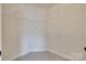Empty walk-in closet with white shelving and neutral carpeting at 8493 Twickenham Ter, Harrisburg, NC 28075