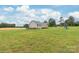 Expansive lawn and the back of the home, which features a wood deck at 8717 Swift Rd, Oakboro, NC 28129