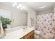 Well-lit bathroom with a floral shower curtain and a vanity with ample counter space at 8717 Swift Rd, Oakboro, NC 28129