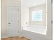Bright bathroom features a soaking tub with glass block window, and tile flooring at 8717 Swift Rd, Oakboro, NC 28129
