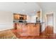 Kitchen showcasing granite countertops, a breakfast bar, wooden cabinetry and hardwood floors at 8717 Swift Rd, Oakboro, NC 28129