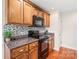 Close-up of the kitchen, showing stainless steel appliances and custom backsplash at 8717 Swift Rd, Oakboro, NC 28129