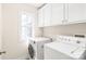 Functional laundry room featuring a white washer and dryer with white cabinetry at 8717 Swift Rd, Oakboro, NC 28129