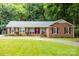 Beautiful front exterior of the home showcasing its brick facade, well-kept lawn, and inviting red door at 8938 Glencroft Rd, Mint Hill, NC 28227