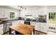 Bright kitchen features white cabinetry, stainless steel appliances, and access to the backyard deck at 8938 Glencroft Rd, Mint Hill, NC 28227