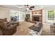 Inviting living room with brick fireplace, wood beam ceiling, and view of dining and kitchen at 8938 Glencroft Rd, Mint Hill, NC 28227