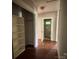 Hallway with wood floors and neutral walls provides access to a bedroom, bathroom, and storage area at 9401 Gold Hill Rd, Mount Pleasant, NC 28124