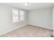 A bright bedroom with neutral walls, plush carpeting, and large windows for natural light at 9464 Lexington Cir # B, Charlotte, NC 28213
