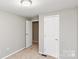 A bedroom featuring a single access door, closet and a neutral-toned carpet at 9464 Lexington Cir # B, Charlotte, NC 28213