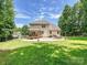 Expansive backyard with a lush lawn, patio, fire pit, and covered deck, perfect for outdoor entertaining at 9507 Reid Hall Ln, Matthews, NC 28105
