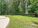 Lush backyard featuring beautiful mature trees, a well-maintained lawn, and relaxing outdoor spaces at 9507 Reid Hall Ln, Matthews, NC 28105
