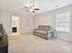 Spacious bedroom with couch and entrance to the bathroom is well-lit by a single window and ceiling fan at 9507 Reid Hall Ln, Matthews, NC 28105