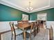 Spacious dining room with dark green walls, wainscoting, and hardwood floors is adjacent to the kitchen at 9507 Reid Hall Ln, Matthews, NC 28105