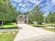 Beautiful two-story home with a manicured lawn, mature trees, and a spacious driveway and attached garage at 9507 Reid Hall Ln, Matthews, NC 28105