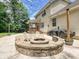 Relaxing outdoor patio featuring a stone fire pit and comfortable seating, ideal for entertaining and relaxation at 9507 Reid Hall Ln, Matthews, NC 28105