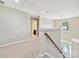 Well-lit landing featuring neutral walls, plush carpeting, and staircase with access to bathroom visible in the background at 9507 Reid Hall Ln, Matthews, NC 28105