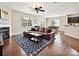 Cozy living room features hardwood floors, a fireplace, a ceiling fan, and a view of the breakfast area at 9507 Reid Hall Ln, Matthews, NC 28105